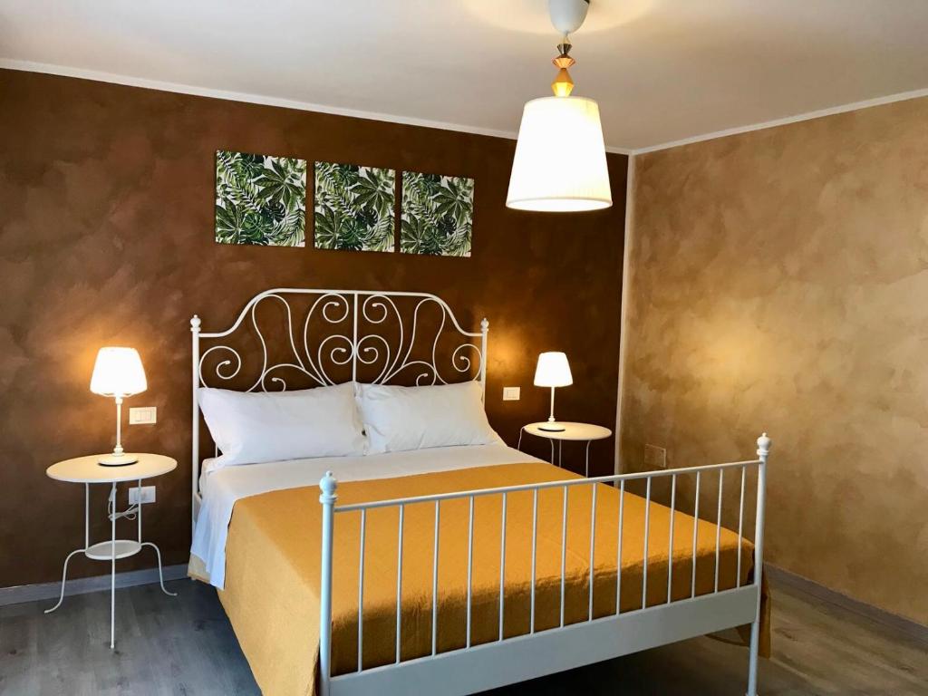 基耶蒂B&B Red Village的一间卧室配有一张带两张桌子和两个窗户的床。