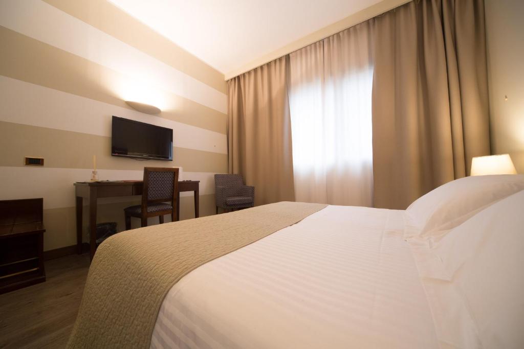 利索内莫泰阿斯科特酒店的酒店客房配有一张床、一张书桌和一台电视。