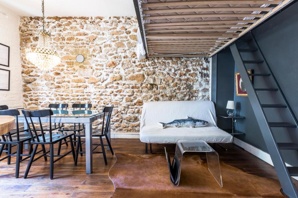 巴黎Cosy 40m² near MONTMARTRE的一间设有桌椅和砖墙的用餐室