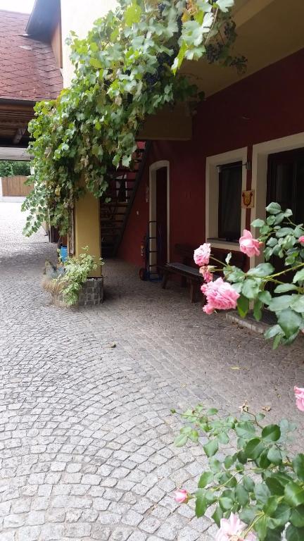 HaunoldsteinGasthof Polly的一座庭院,里面种满了鲜花,在建筑物里设有长凳