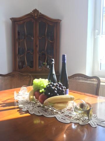 巴特索伯恩海姆Marumparkblick的一张桌子,上面放有一盘水果和葡萄酒瓶