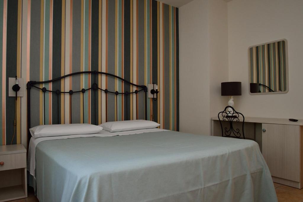 圣安杰洛城Alloggio nonna Cornelia的一间卧室配有一张床和条纹墙