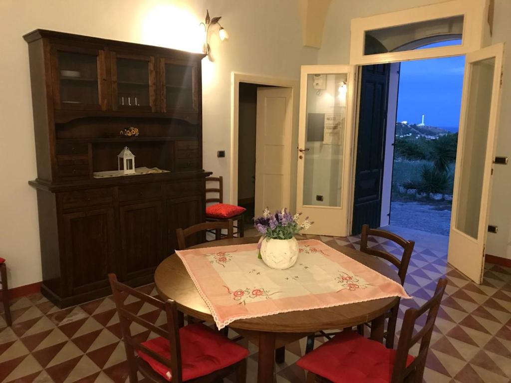 莱乌卡Villa De Luca的用餐室,配有一张桌子和花瓶
