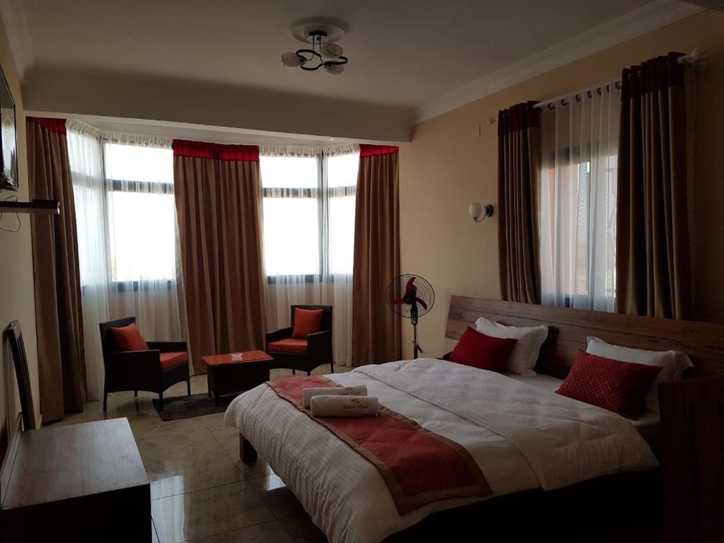 穆龙达瓦Select Hôtel的一间卧室配有一张带红色枕头的大床