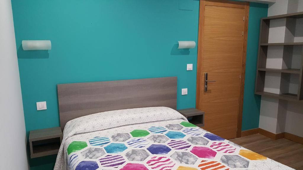 拉雷多罗西旅馆的一间卧室设有一张床和蓝色的墙壁