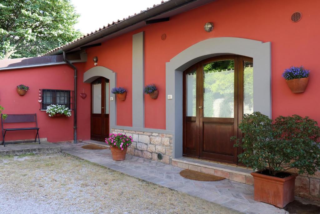 阿西西IL TURRIONE "app. San Rufino"的红色的房子,设有木门和长凳