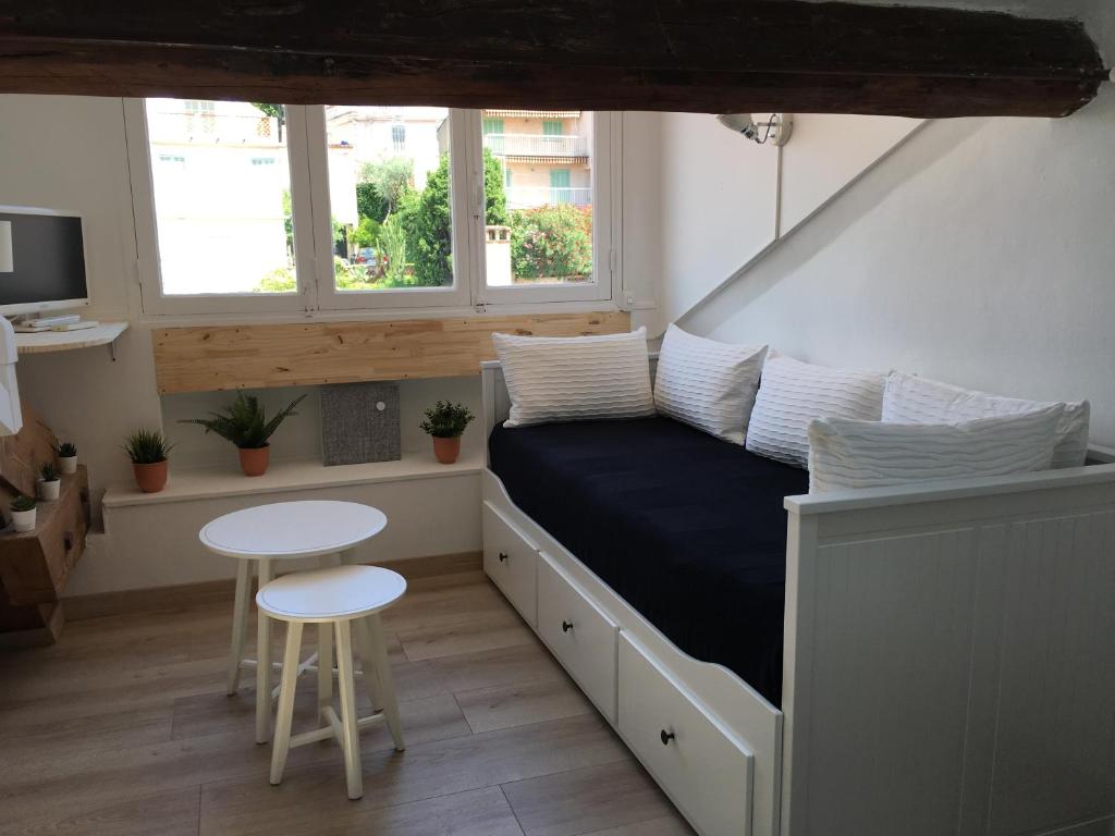戛纳Studio centre ville Cannes 200 mètres des plages du midi的一间卧室配有一张带桌子和两张凳子的床