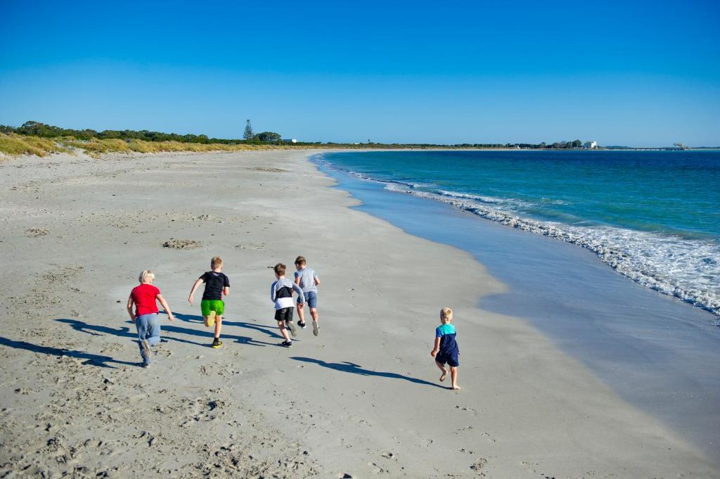 CoogeeDiscovery Parks - Woodman Point的一群在海滩上散步的儿童