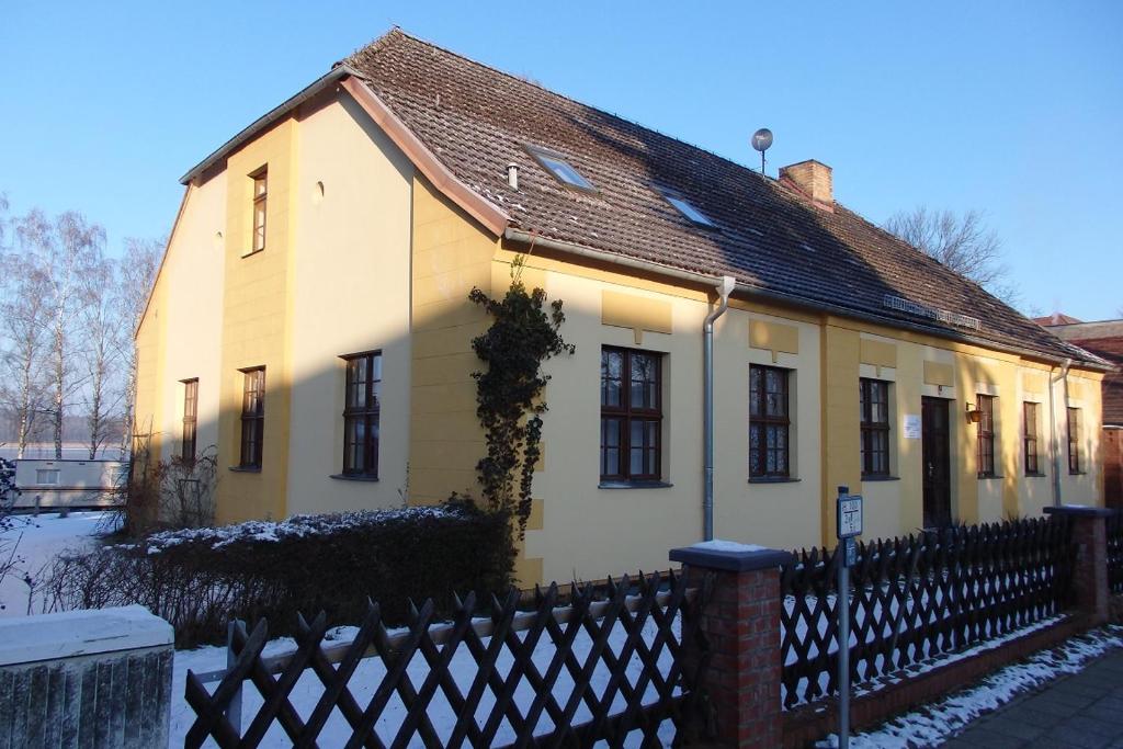 赖因斯贝格Ferienwohnung Rheinsberg的前面有栅栏的白色房子