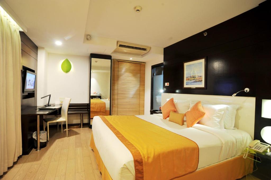达卡铂金酒店的酒店客房设有一张大床和一张书桌。