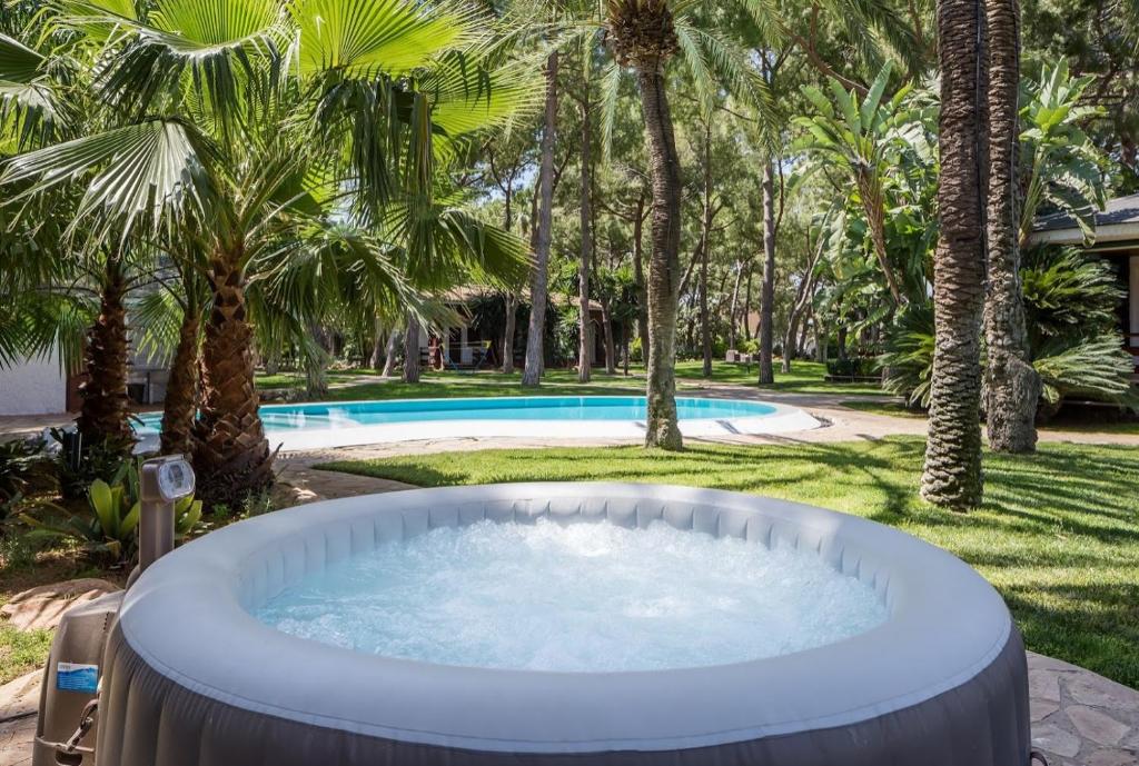 莱利亚纳El Oasis Villa Resort的棕榈树庭院内的热水浴池