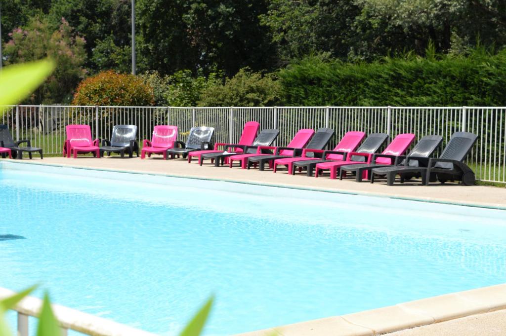 梅里尼亚克Zenitude Hôtel-Résidences Bordeaux Aéroport Mérignac的游泳池旁一排粉红色椅子
