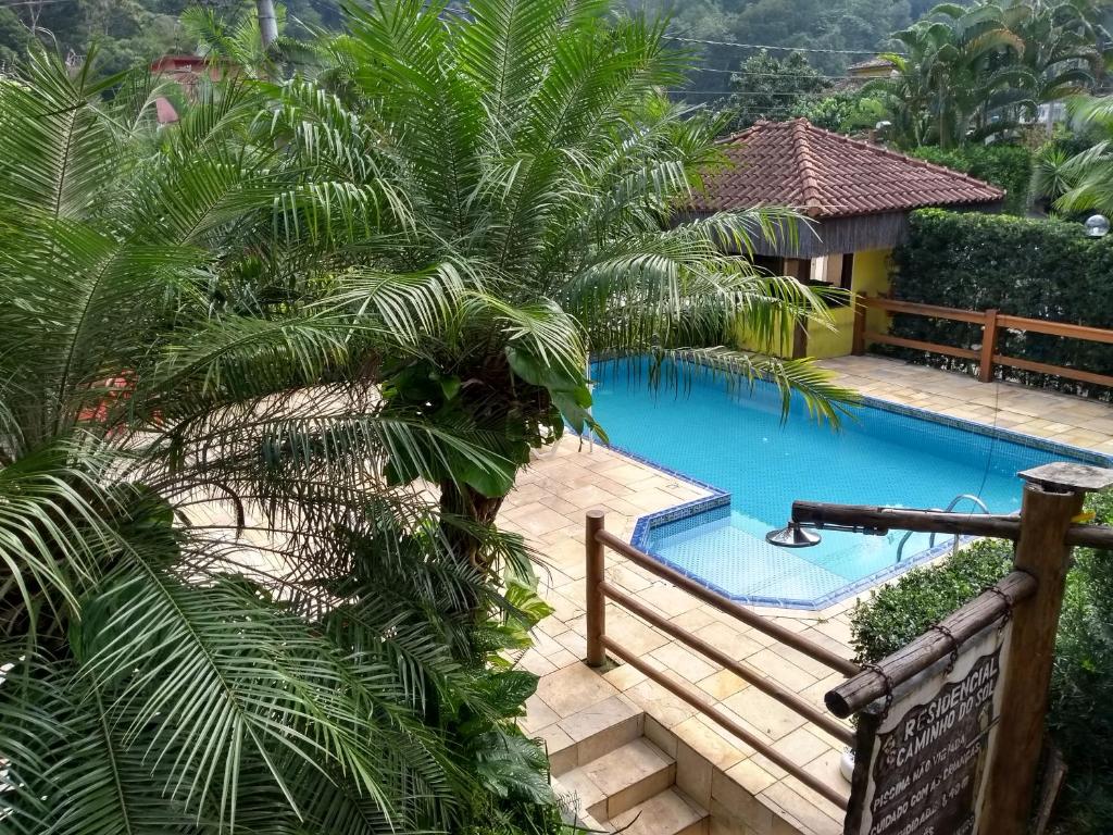 博西坎加RC Sol de Boiçucanga - Suite的棕榈树度假村内的游泳池