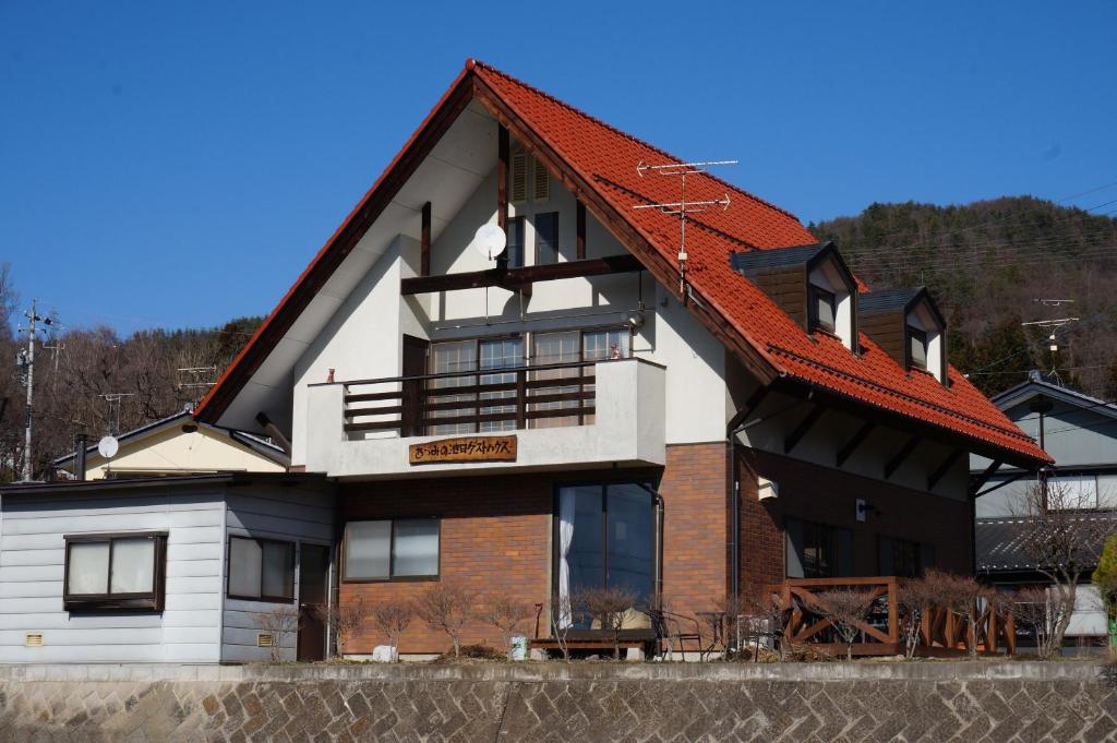 安昙野市Azumino Ikeda Guesthouse的红色屋顶的房子