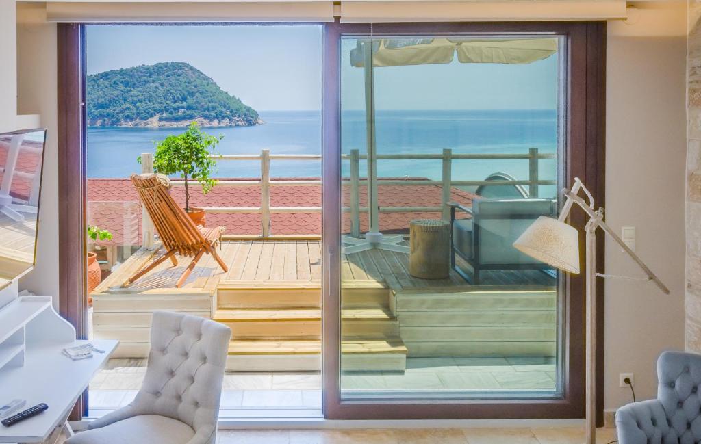 基尼拉Agorastos Suites的客房设有滑动玻璃门,享有海景。
