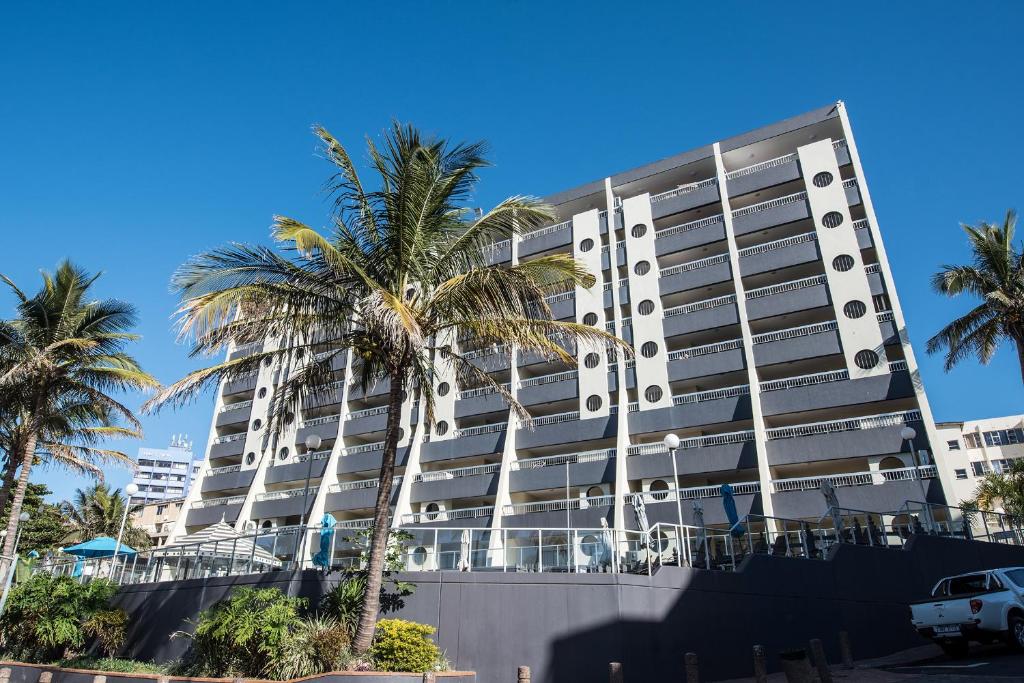 马盖特First Group Margate Sands的一座高大的建筑,前面有棕榈树
