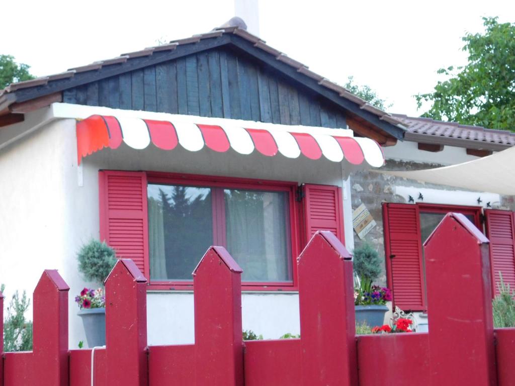 卡尔派尼西翁1957 To Rodo kai to Roido的红色百叶窗房子前面的红色围栏