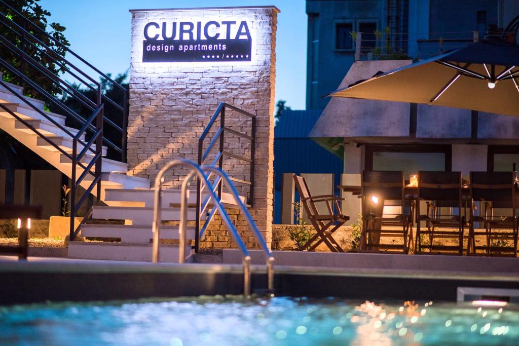 克尔克CURICTA Design Apartments的一座游泳池,旁边有一个读卡片的标志