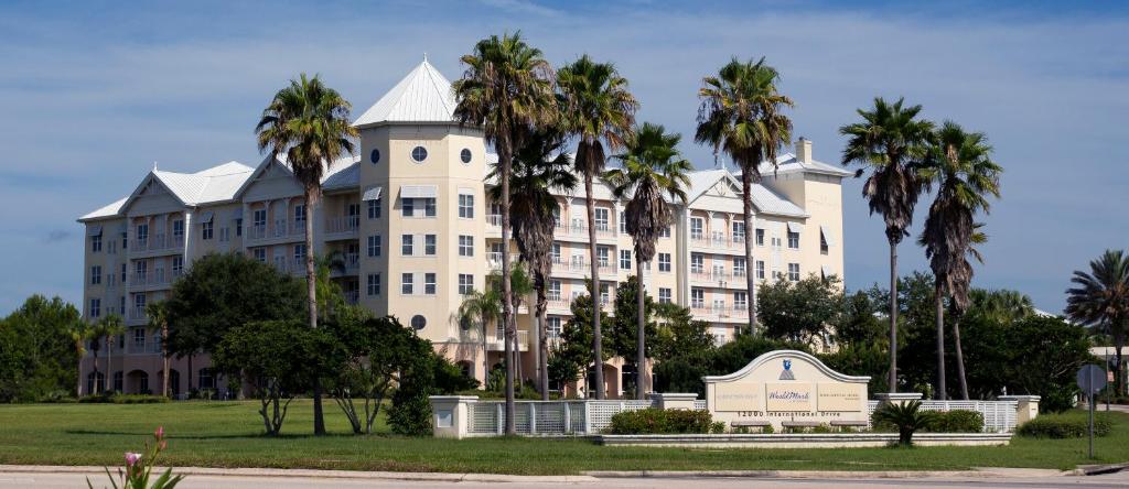 奥兰多奥兰多纪念酒店的一座白色的大建筑,前面有棕榈树