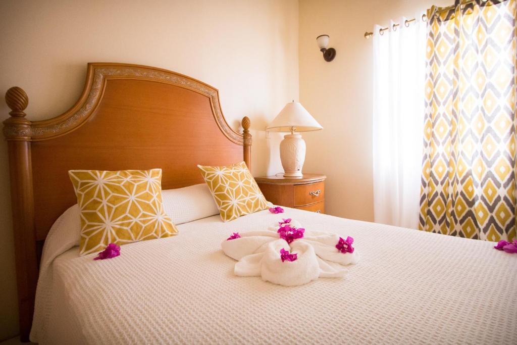 圣约翰斯康妮舒适套房酒店的一间卧室配有带毛巾和鲜花的床