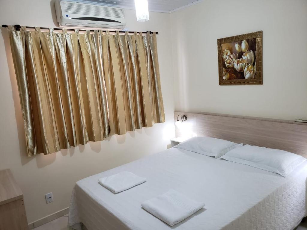 伊瓜苏Felipe Family Houses - Casas de temporada的卧室配有白色的床和窗户。