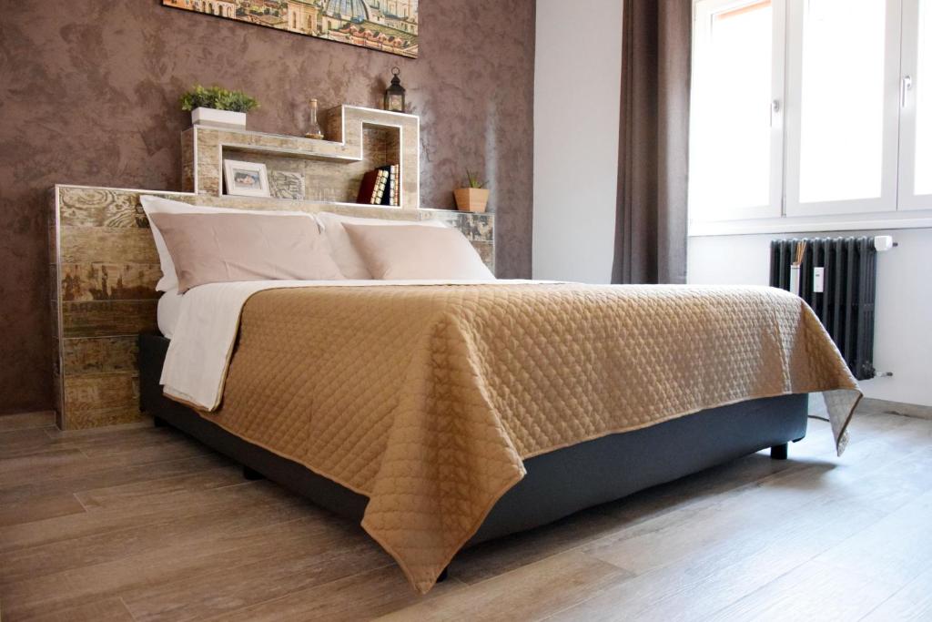 罗马Damiva的一间卧室配有一张带棕色毯子的大床