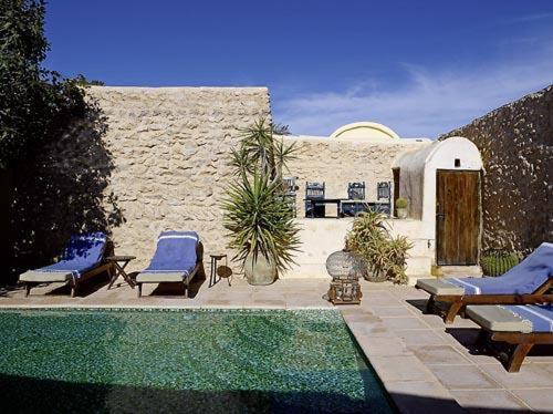 乌姆苏克达尔迪阿发酒店的一座带椅子的庭院和一座位于大楼前的游泳池