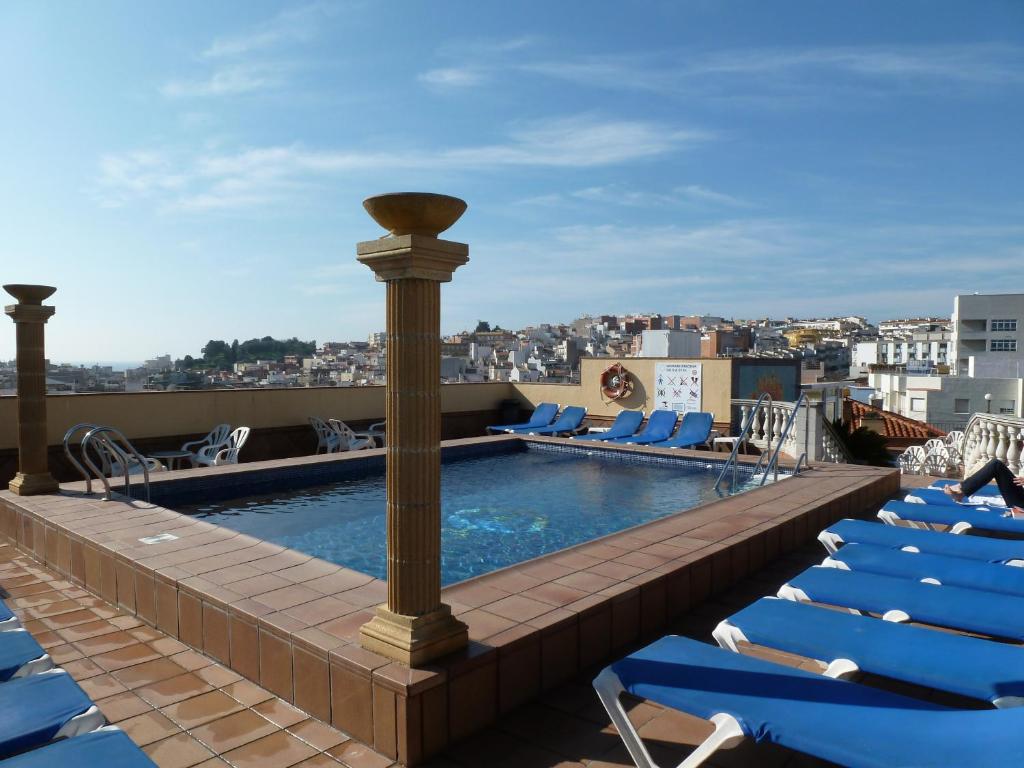布拉内斯布拉瓦海岸酒店 的一座带躺椅的建筑屋顶上的游泳池