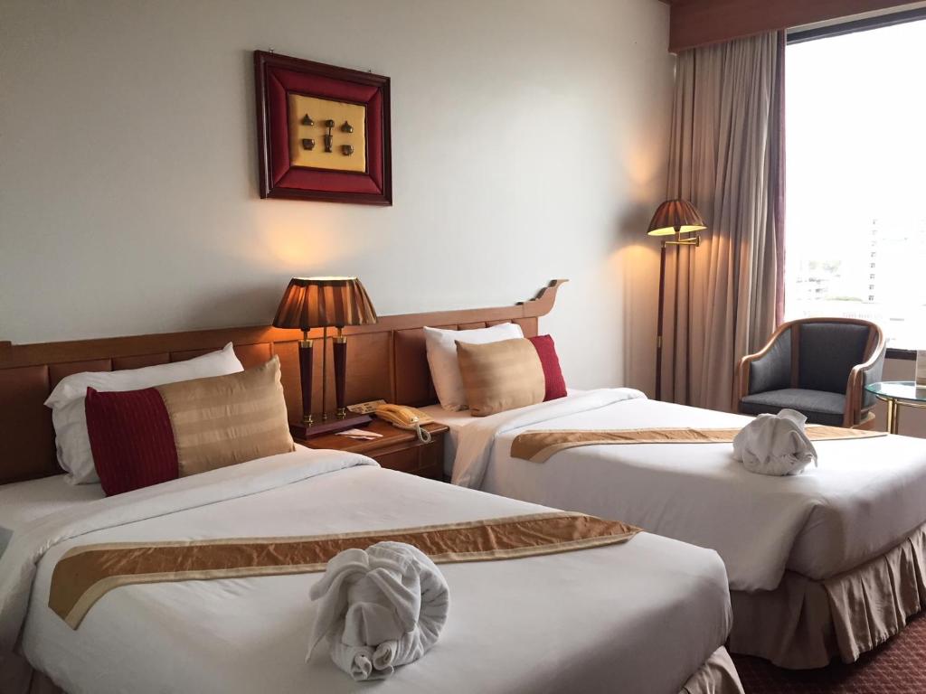乌汶莱丝翁酒店的酒店客房,配有两张床和椅子