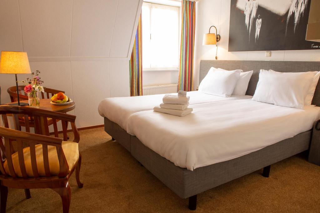 亨厄费尔德荷兰之家的一间卧室配有一张带椅子的床和一扇窗户
