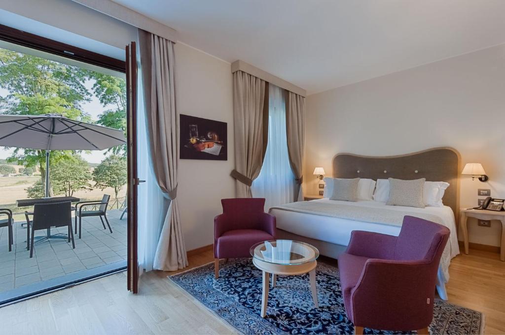 乔治堡Borgo La Chiaracia Resort & SPA的一间卧室配有一张床,庭院配有桌子