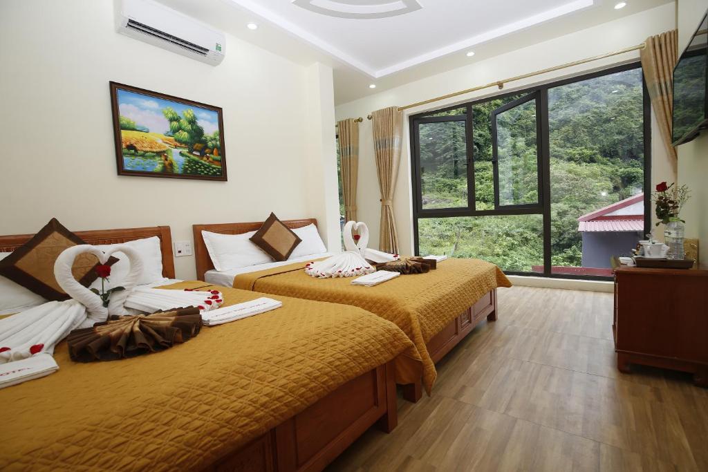 吉婆岛Hoang Phuc Hotel Cat Ba的酒店客房设有两张床和窗户。