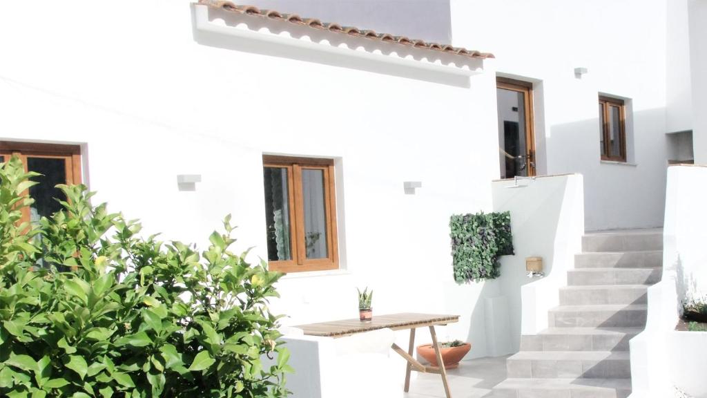 阿尔热祖尔Casa D' Avó Bia - Renovated House的白色的房子,设有楼梯和桌子
