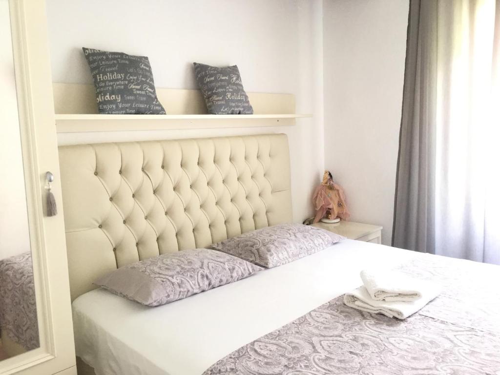卡瓦拉Sweet Rooms Kavala的卧室内的一张带白色床头板的床