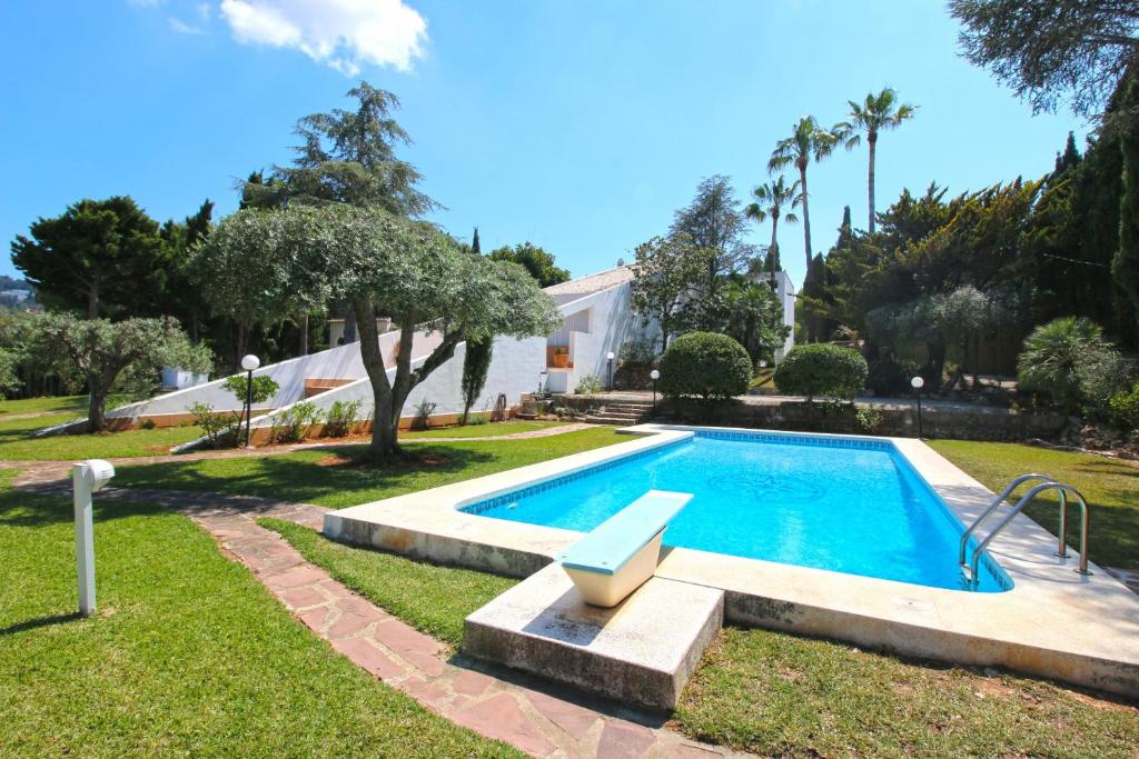 佩德雷尔Finca la Xara的庭院内带长凳的游泳池
