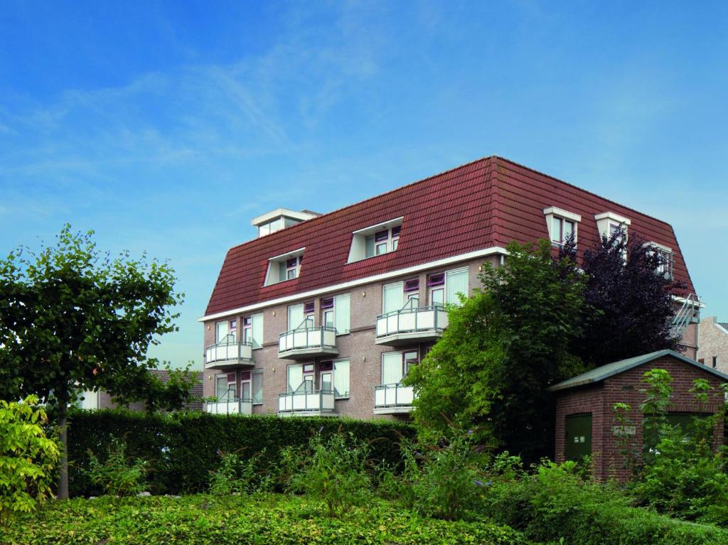 奥依吉弗莱彻酒店的一座红屋顶的大型砖砌建筑