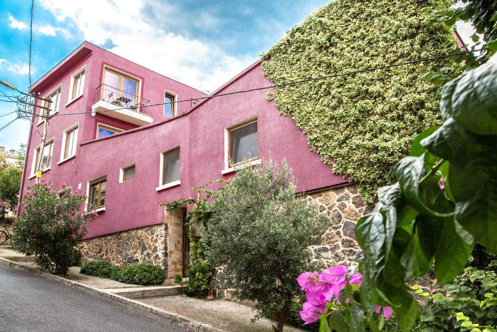 雷贝里岛里索拉旅馆的一座粉红色的建筑,旁边是常春藤