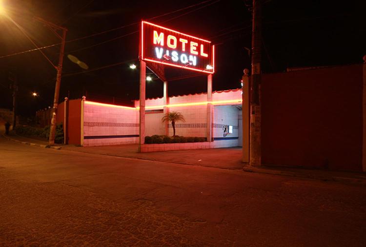 瓜鲁柳斯Motel Vison (Próximo GRU Aeroporto)的夜间大楼一侧的汽车旅馆标志