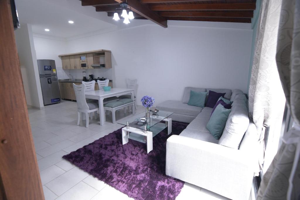 麦德林apartamentos casa Margarita en laureles estadio su hogar en Medellin的客厅配有白色的沙发和桌子
