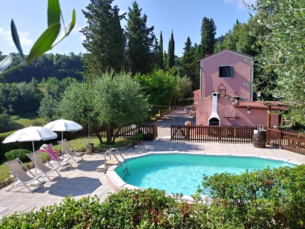 帕拉伊阿Podere Il Leccione的一座房子前面的游泳池,有一座建筑