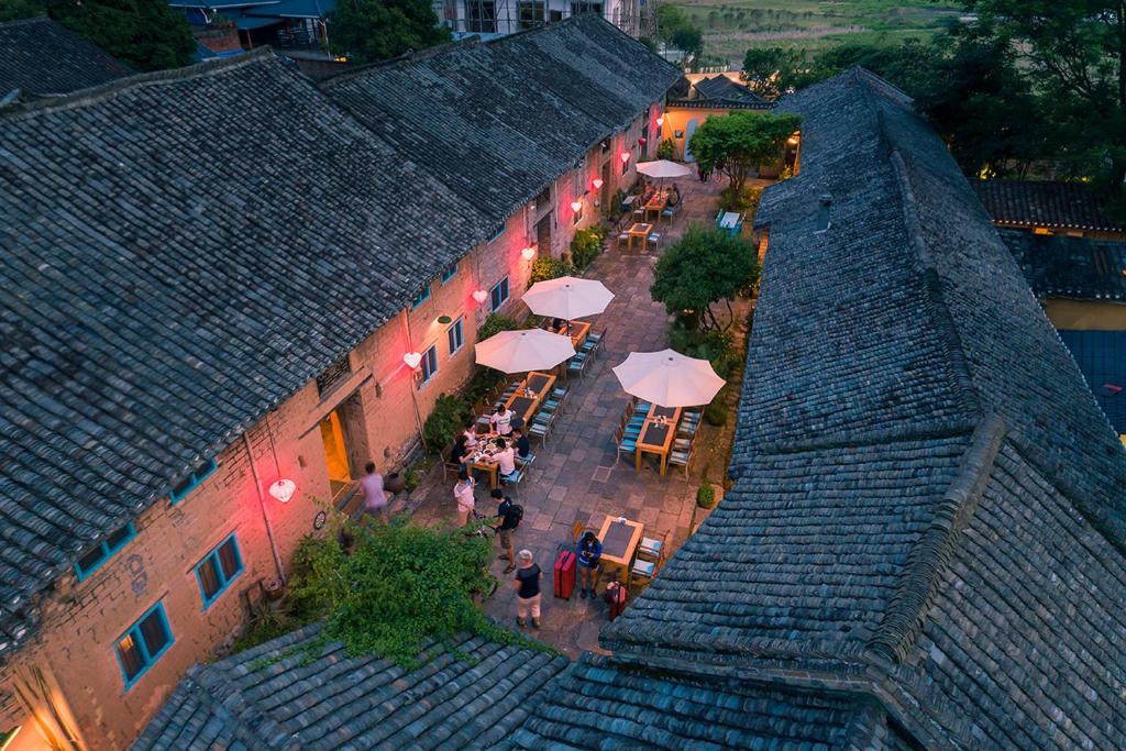 阳朔阳朔格格树饭店的享有带桌子和遮阳伞的天井的顶部景致。