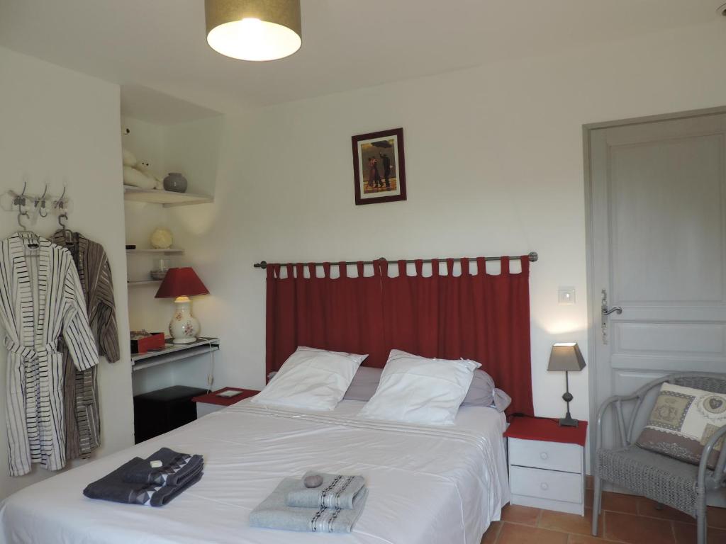 卡瓦永Le Faré Tchanqué Chambre d’hôtes Référence的一间卧室配有一张红色床头板的床