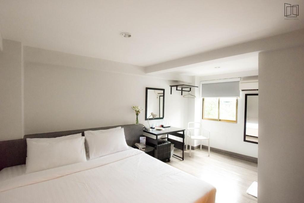 曼谷娜娜城市酒店的卧室配有白色的床和书桌