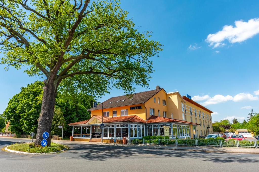 吕肖卡特贝格舒适酒店的前面有一棵树的大建筑