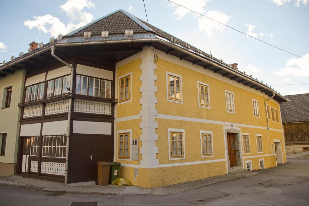 博希尼The 1882 Old House Vodnikova的街道上带阳台的黄色建筑