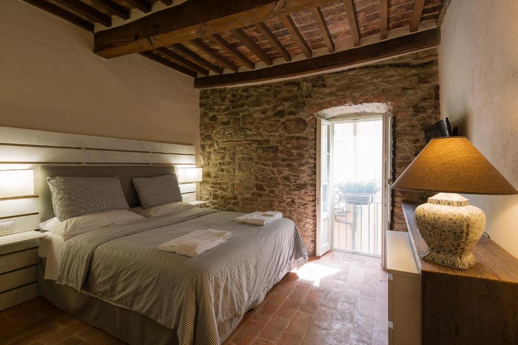 科尔托纳Casa Zeni的一间卧室设有一张床和石墙