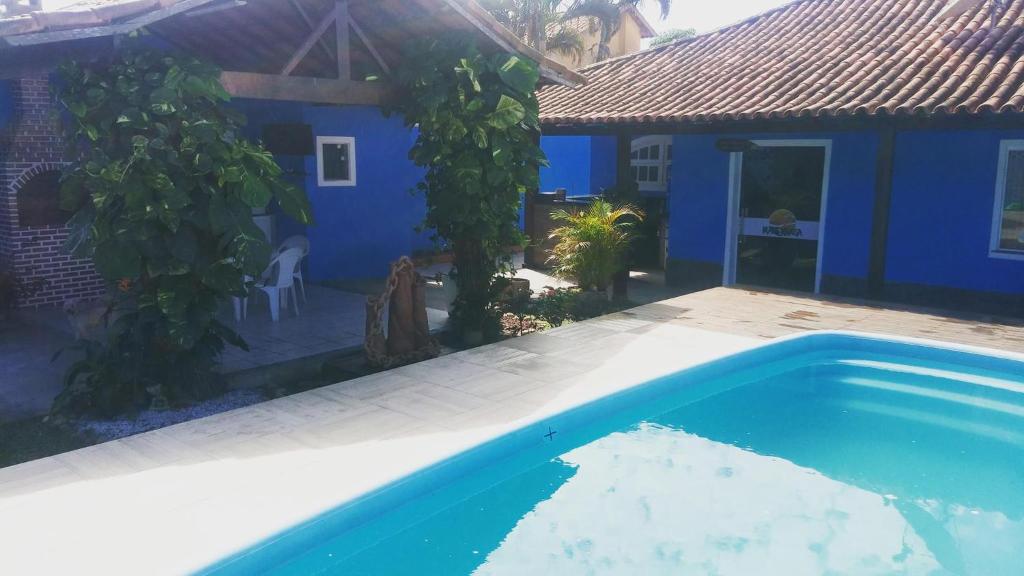 卡波布里奥Hostel Maré Mansa的蓝色的房子,前面设有一个游泳池