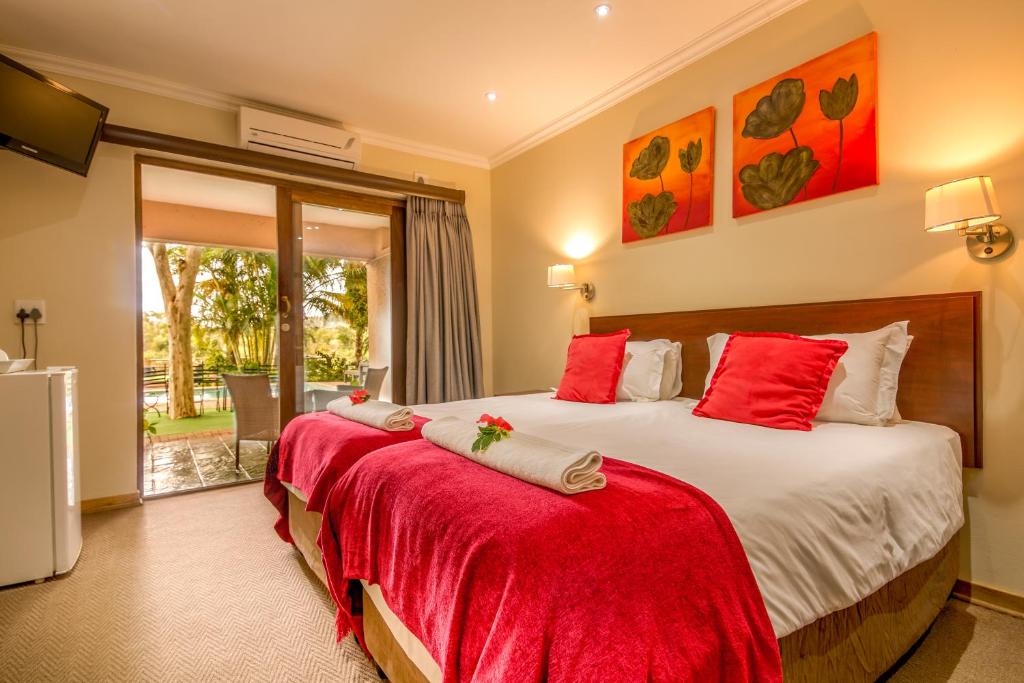 马里兰里约维斯塔旅舍的一间卧室配有两张带红色枕头的床