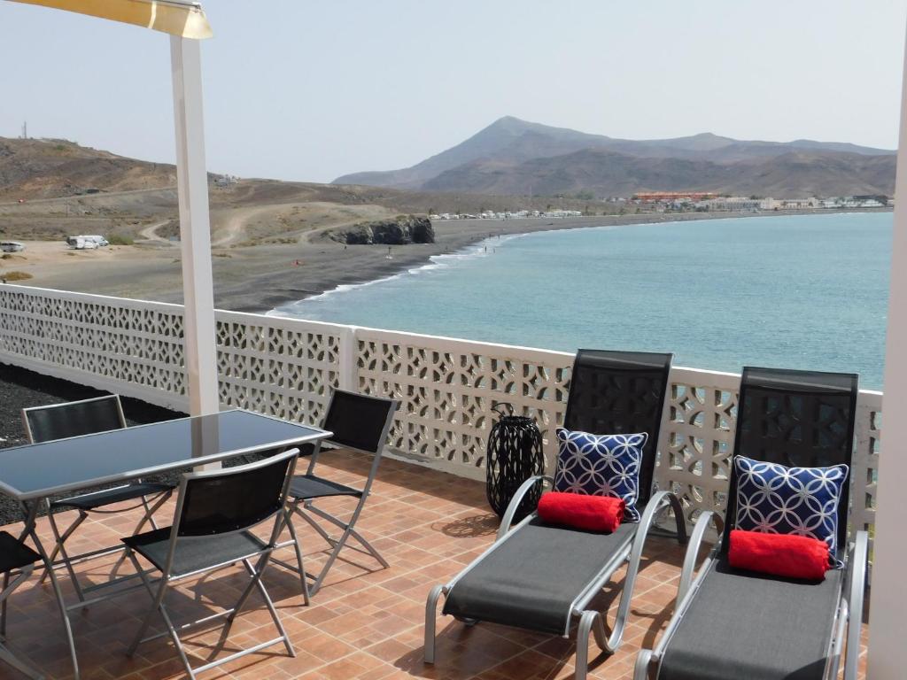 塔拉哈勒赫El Roquito Ocean View的一个带桌椅的庭院和海滩