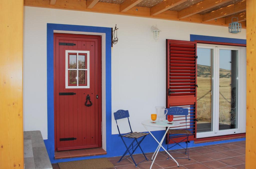 莫托拉Casa dos Corvos的红色门和桌子的房子